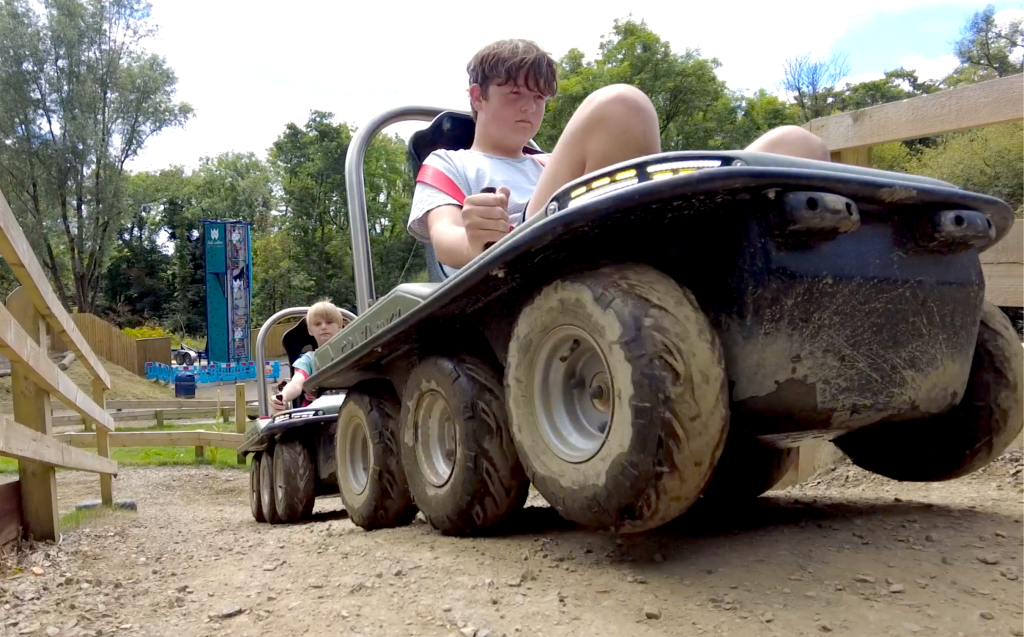 A child driving an all-electric Crazi-Bugz off-road buggy along a dirt track at Llys-y-Frân.