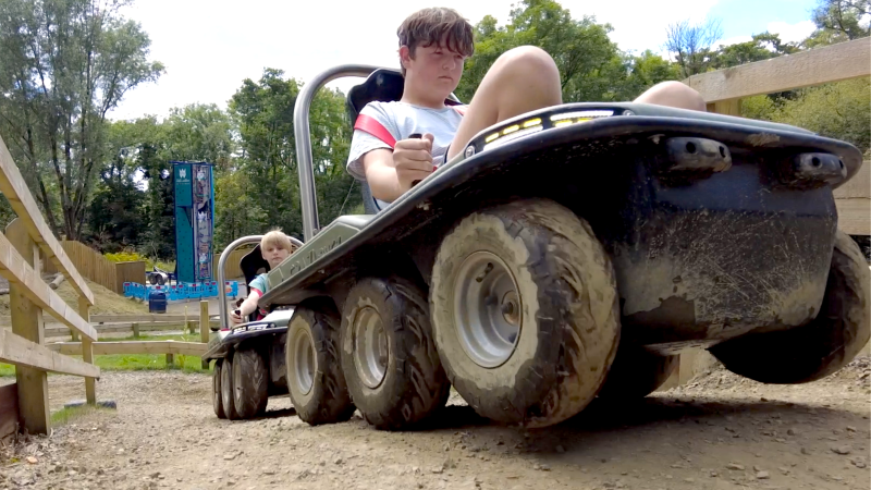 A child driving an all-electric Crazi-Bugz off-road buggy along a dirt track at Llys-y-Frân.